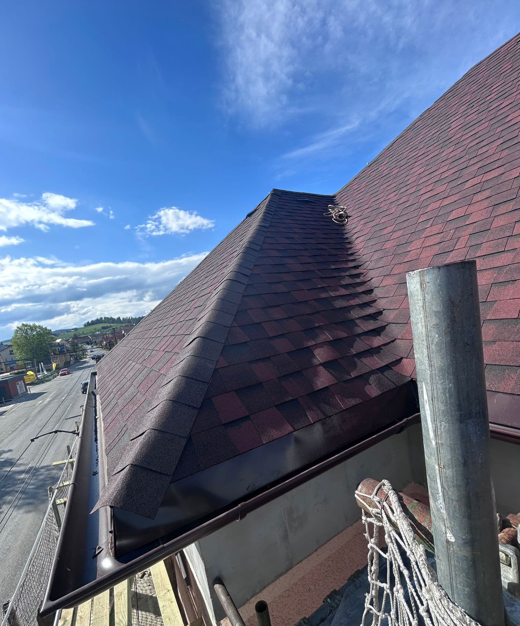 Pokrývač pracujúci na streche s taškovou krytinou